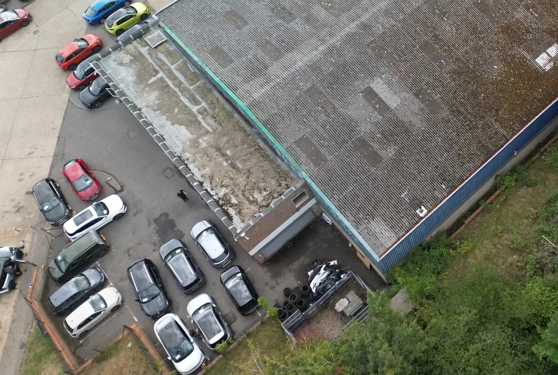 flat roof, cars and a small pedestrian.