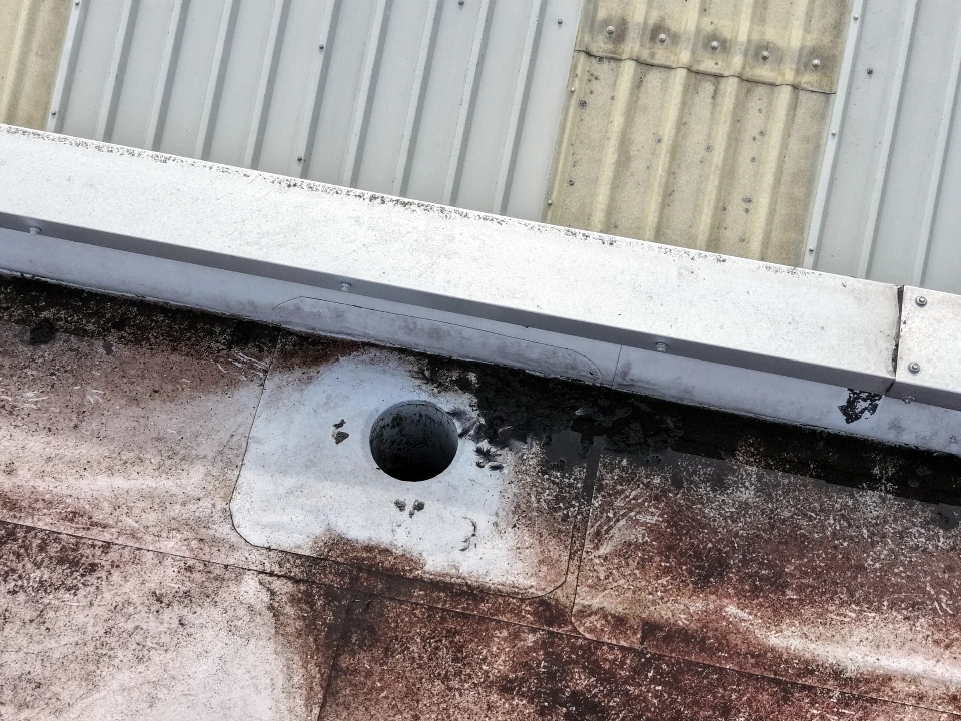 Parapet corner with outlet and stain.