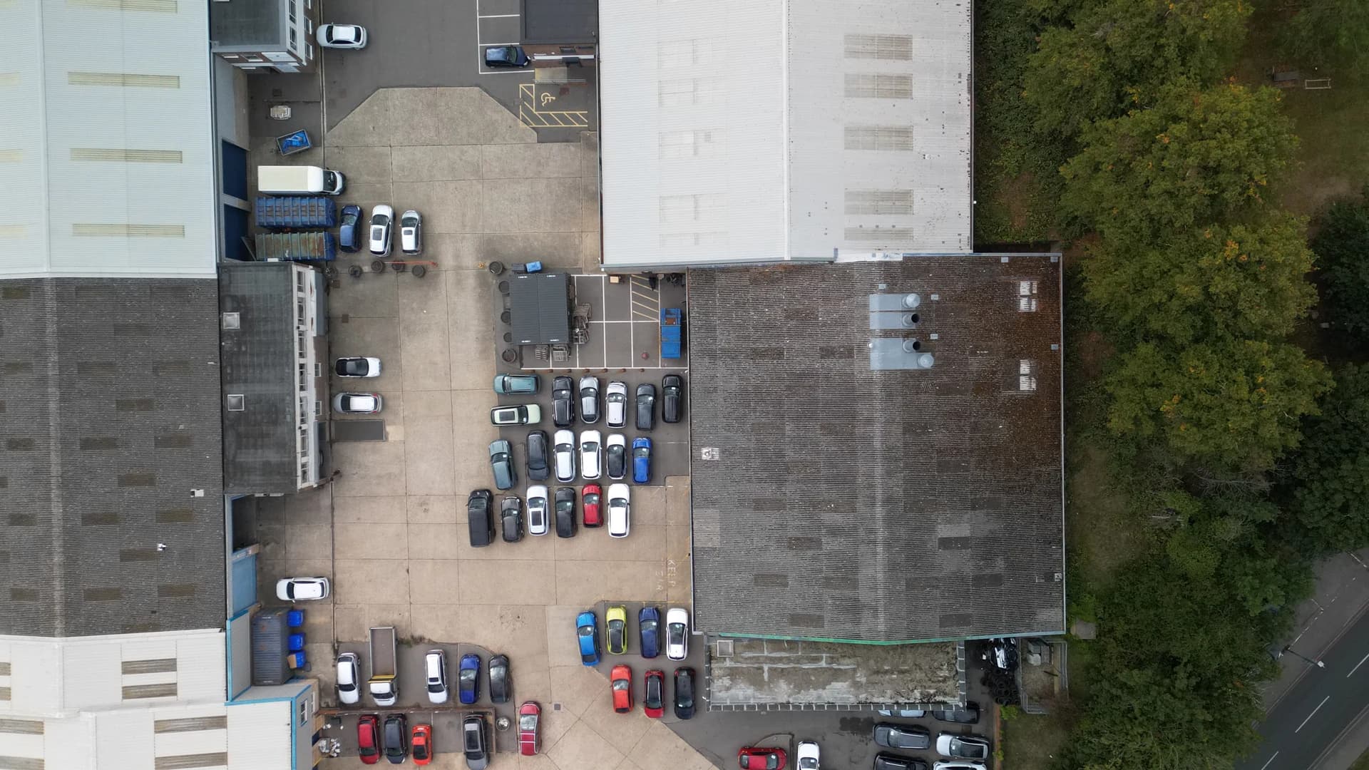 Top-down plan of the wider site: roofs and car parks.