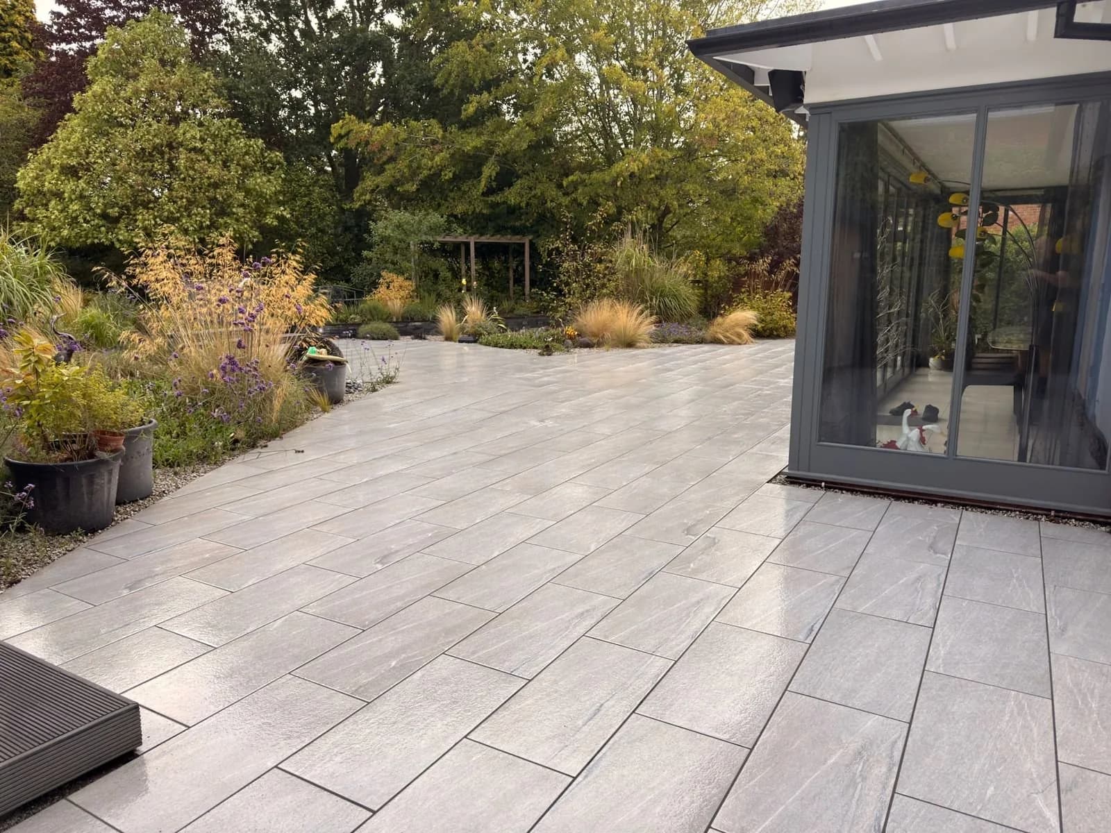 Restored grey porcelain patio beside a garden room in Stratford-upon-Avon