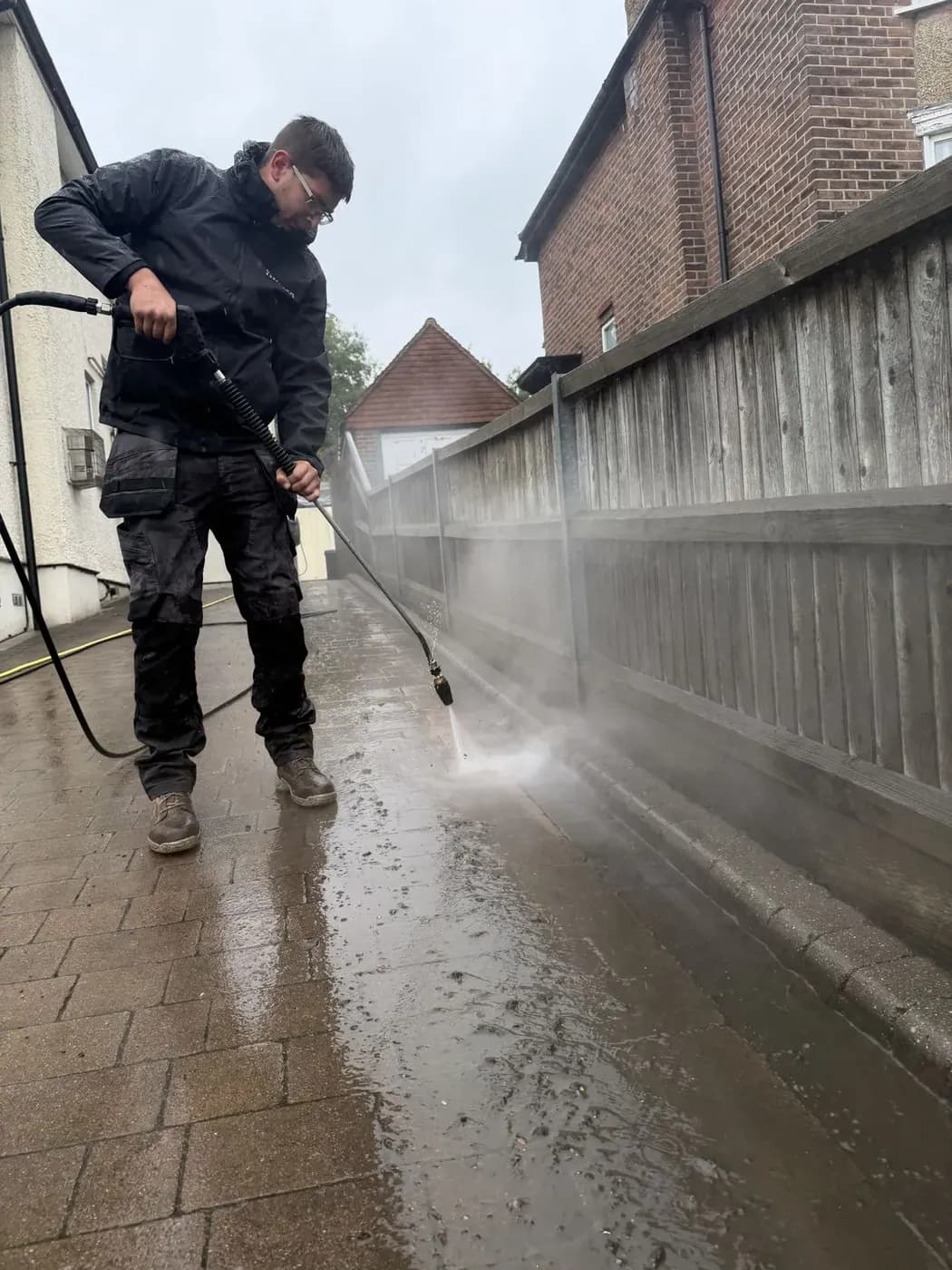 Chiltern Surface Co technician deep cleaning block paving along the edge of a driveway
