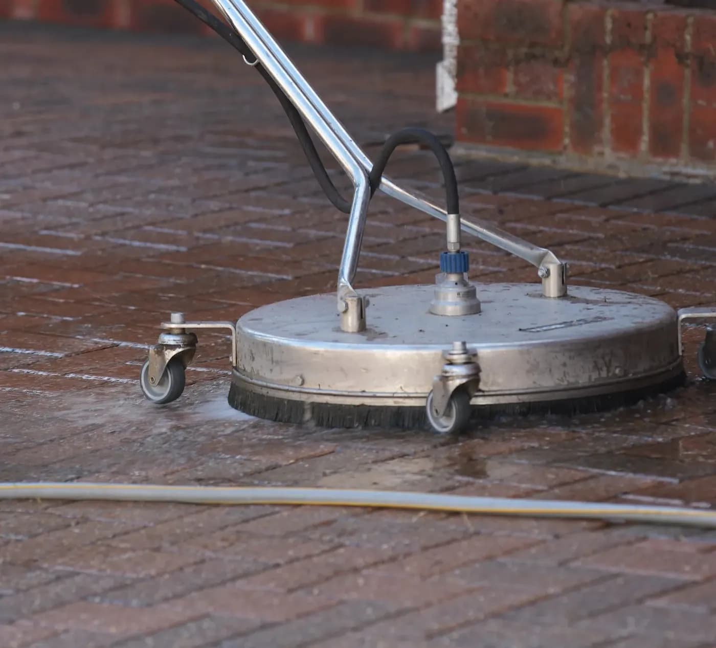 Rotary surface cleaner head deep cleaning wet block paving on a driveway