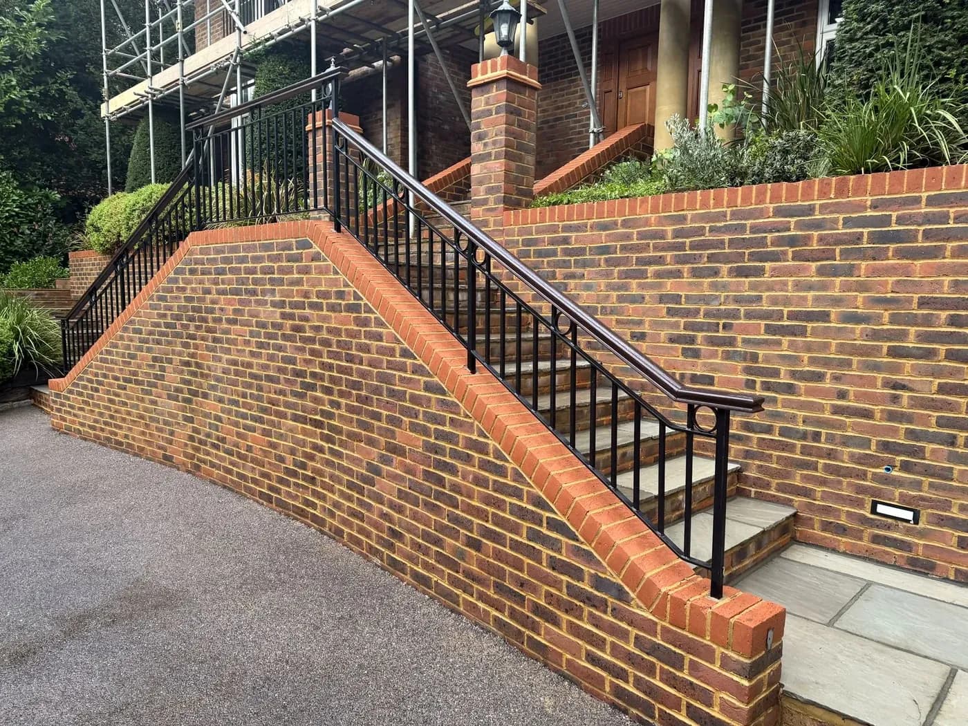 Brick retaining wall and coping after soft washing, black algae removed from the face