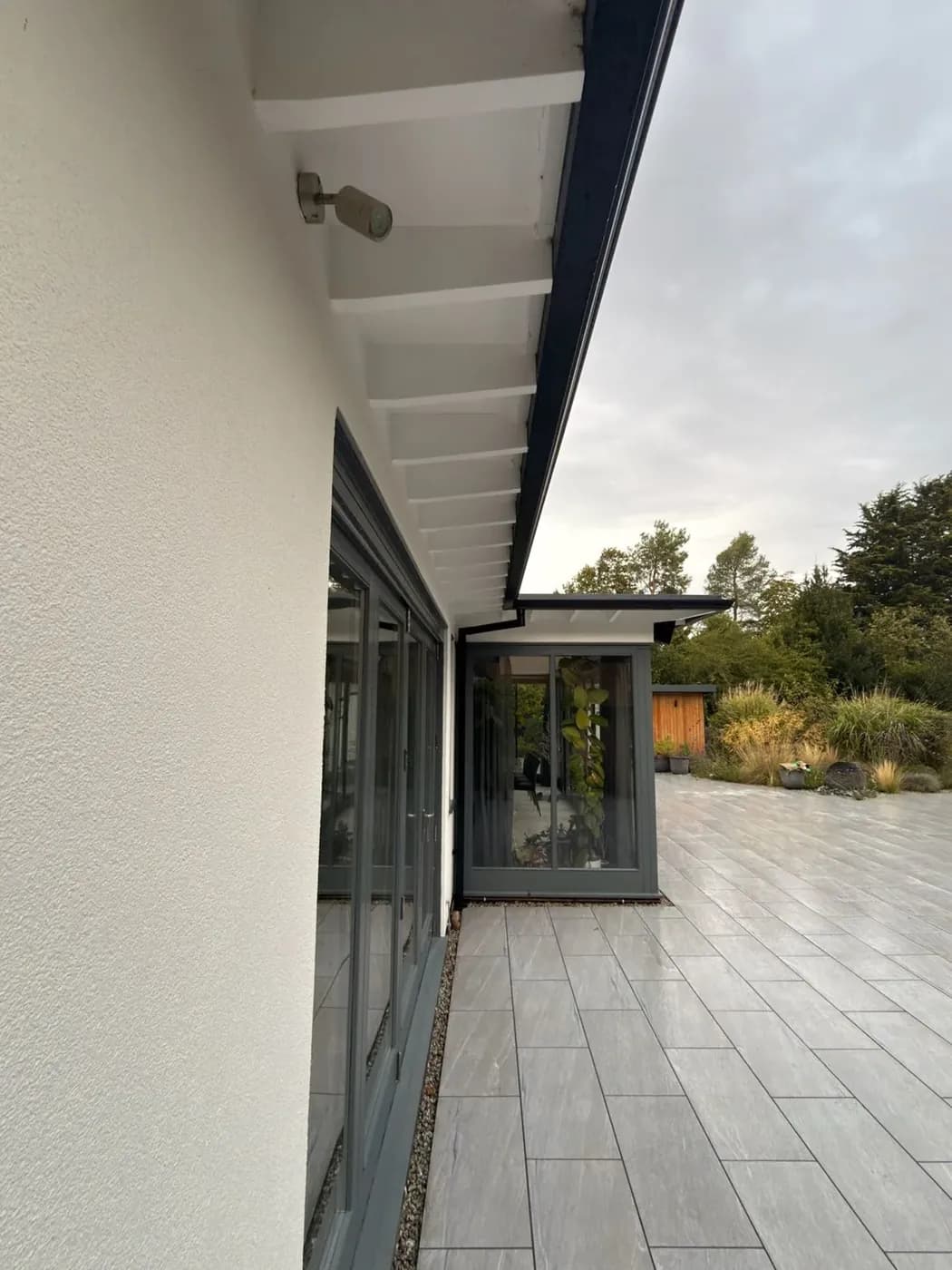 Soffit line and rear glazing of a rendered house after soft washing