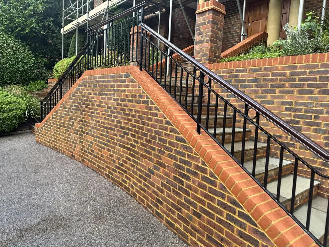 Brick ramp wall and railings after soft washing, the brickwork clean and even