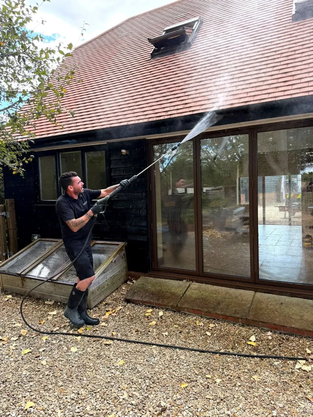 Chiltern Surface Co technician cleaning down timber-clad walls at low pressure