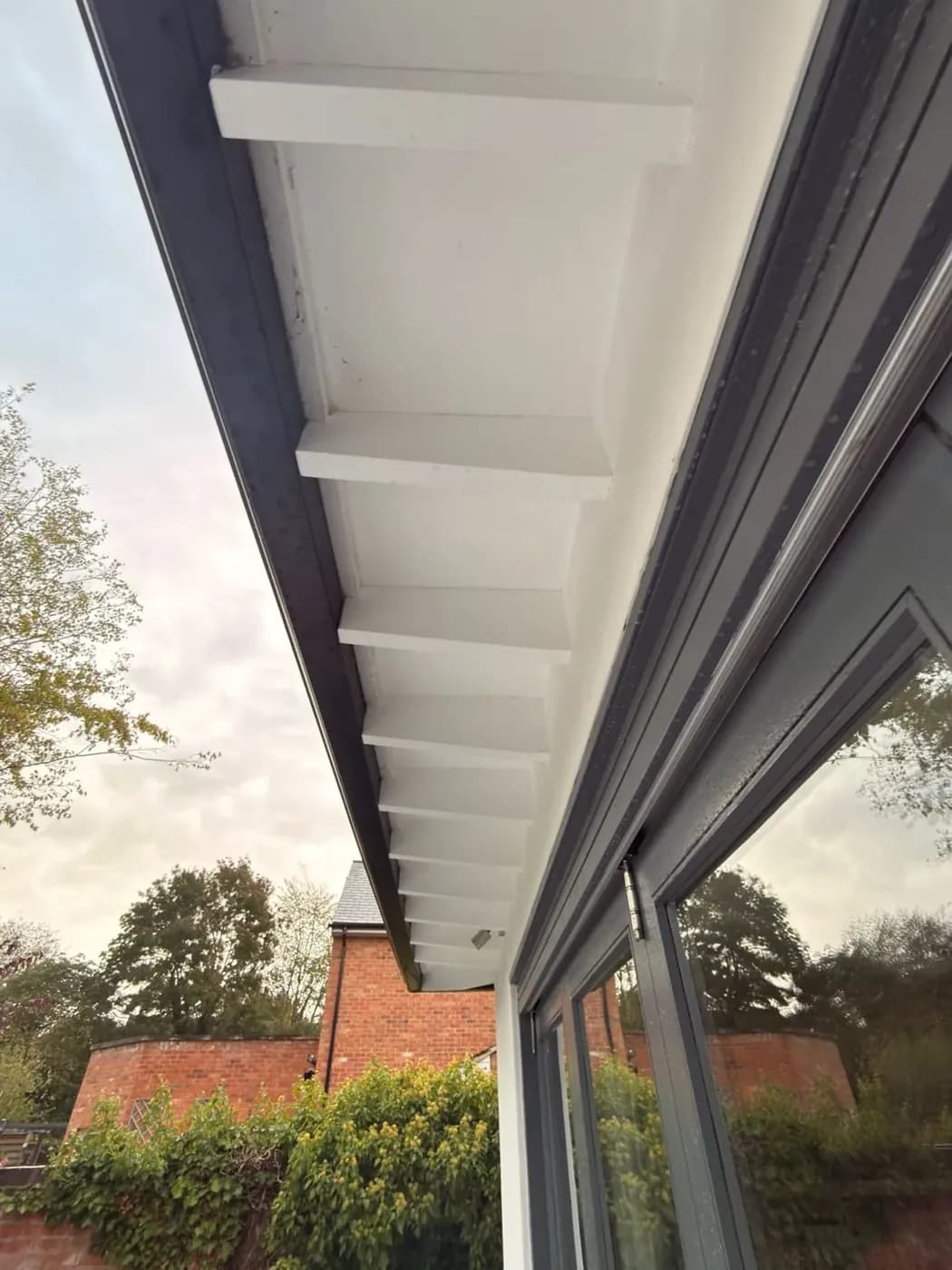 Soffit above rear glazing after the soft wash treatment, cobwebs and grime gone