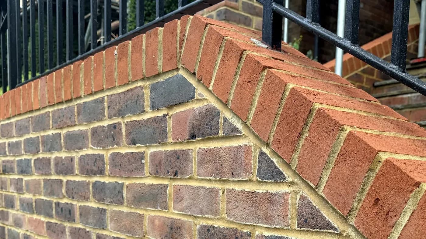 Brick garden wall and coping after soft washing, the algae lifted from the brick