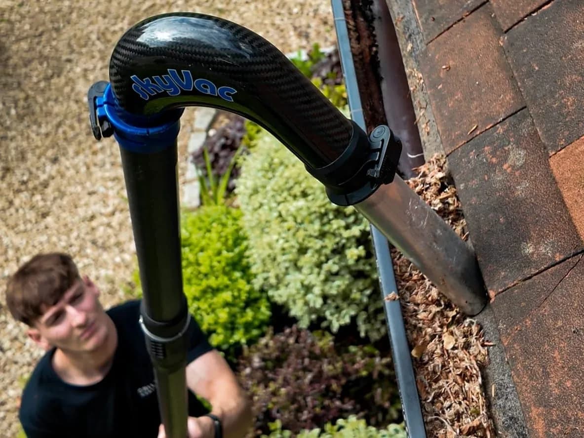 Gutter clearing with a gutter vacuum operated from the ground