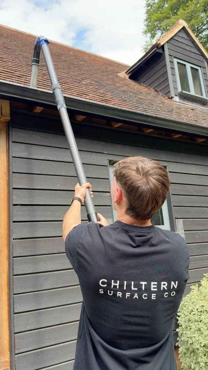 Vacuum gutter cleaning on the gutter of a garden outbuilding