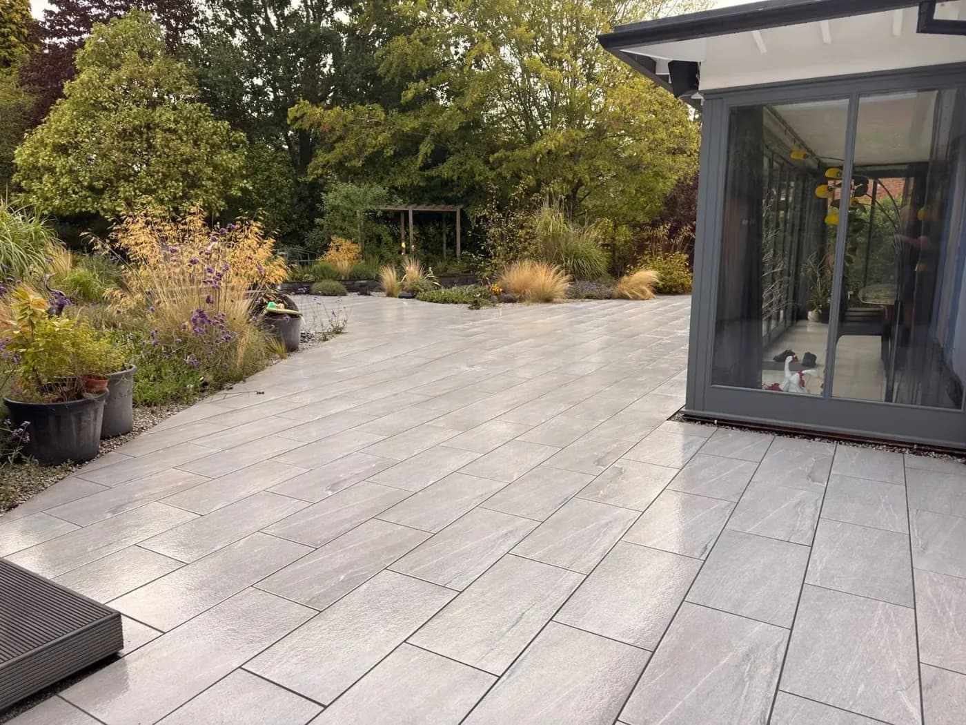 Porcelain patio beside a garden room after deep cleaning and repointing