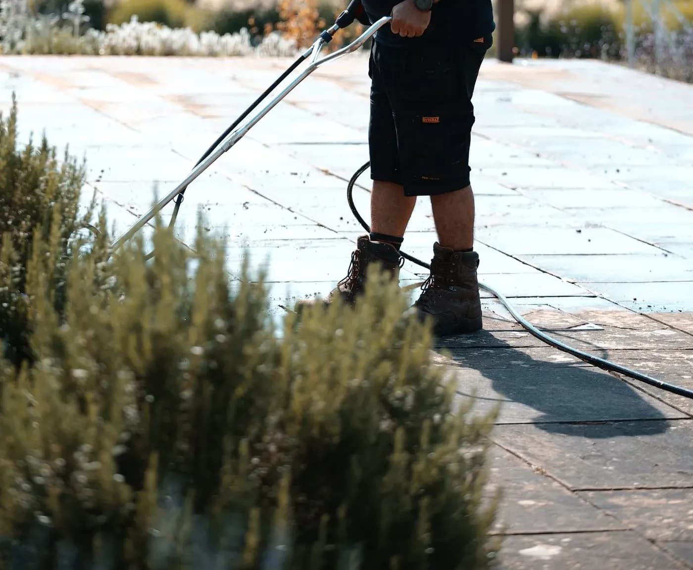 Cleaning lance working across Indian sandstone paving at controlled pressure
