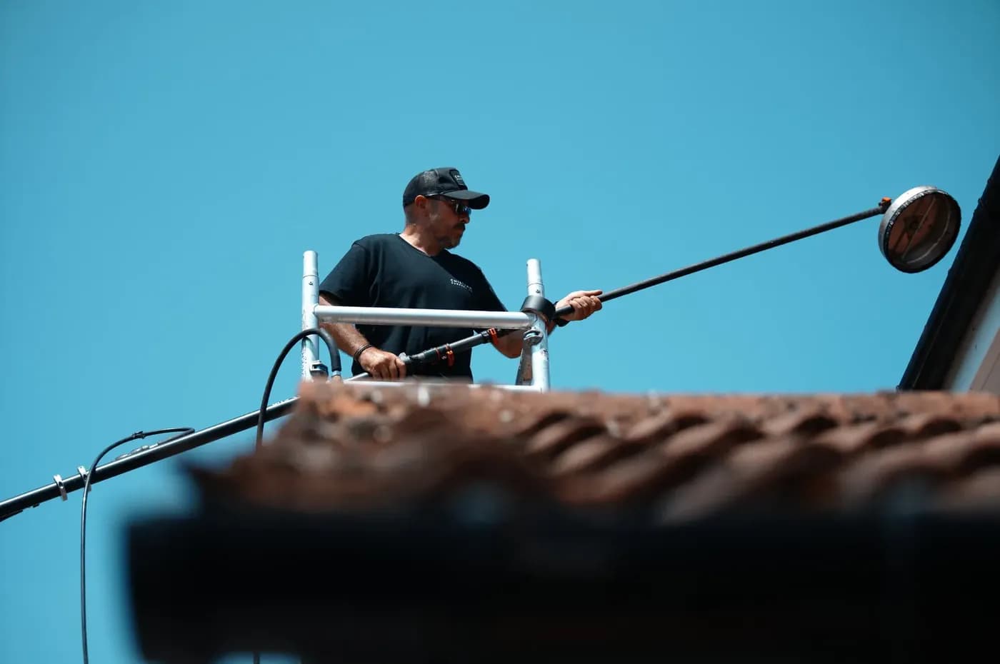 Concrete tile roof being cleaned from a scaffold tower at low pressure