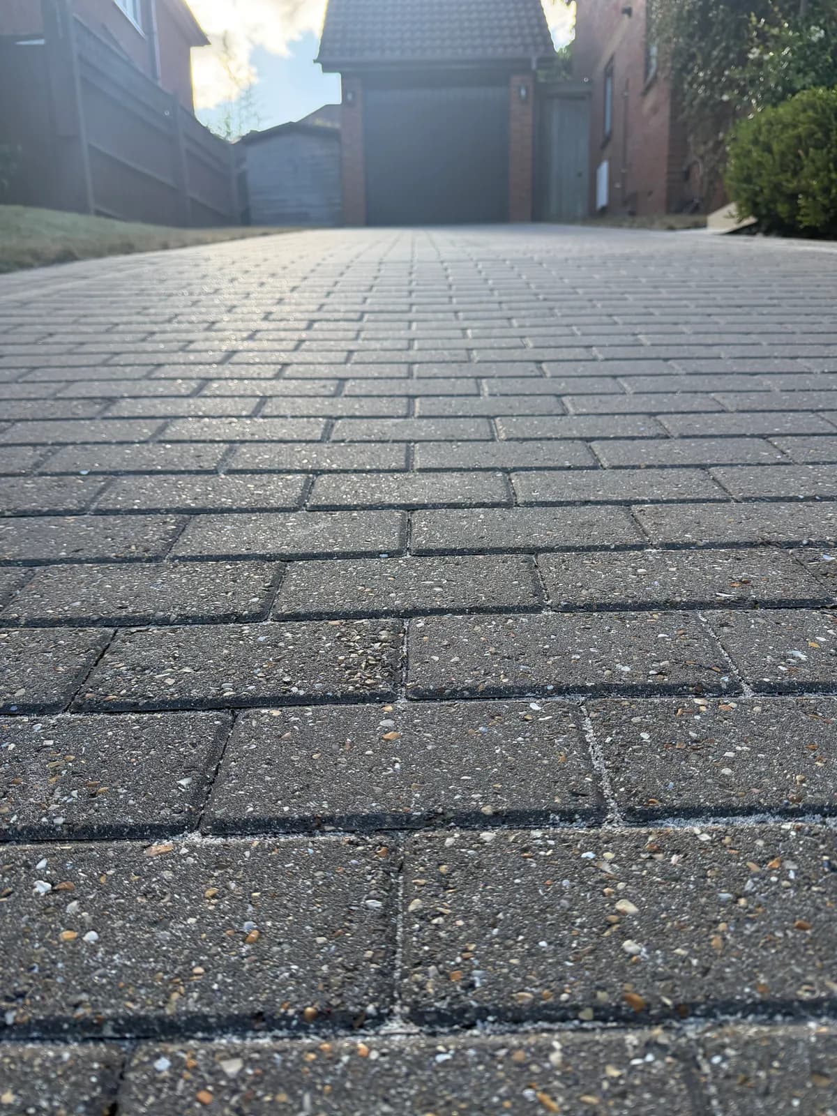 Block-paved driveway being cleaned by Chiltern Surface Co, the paving surface filling the frame