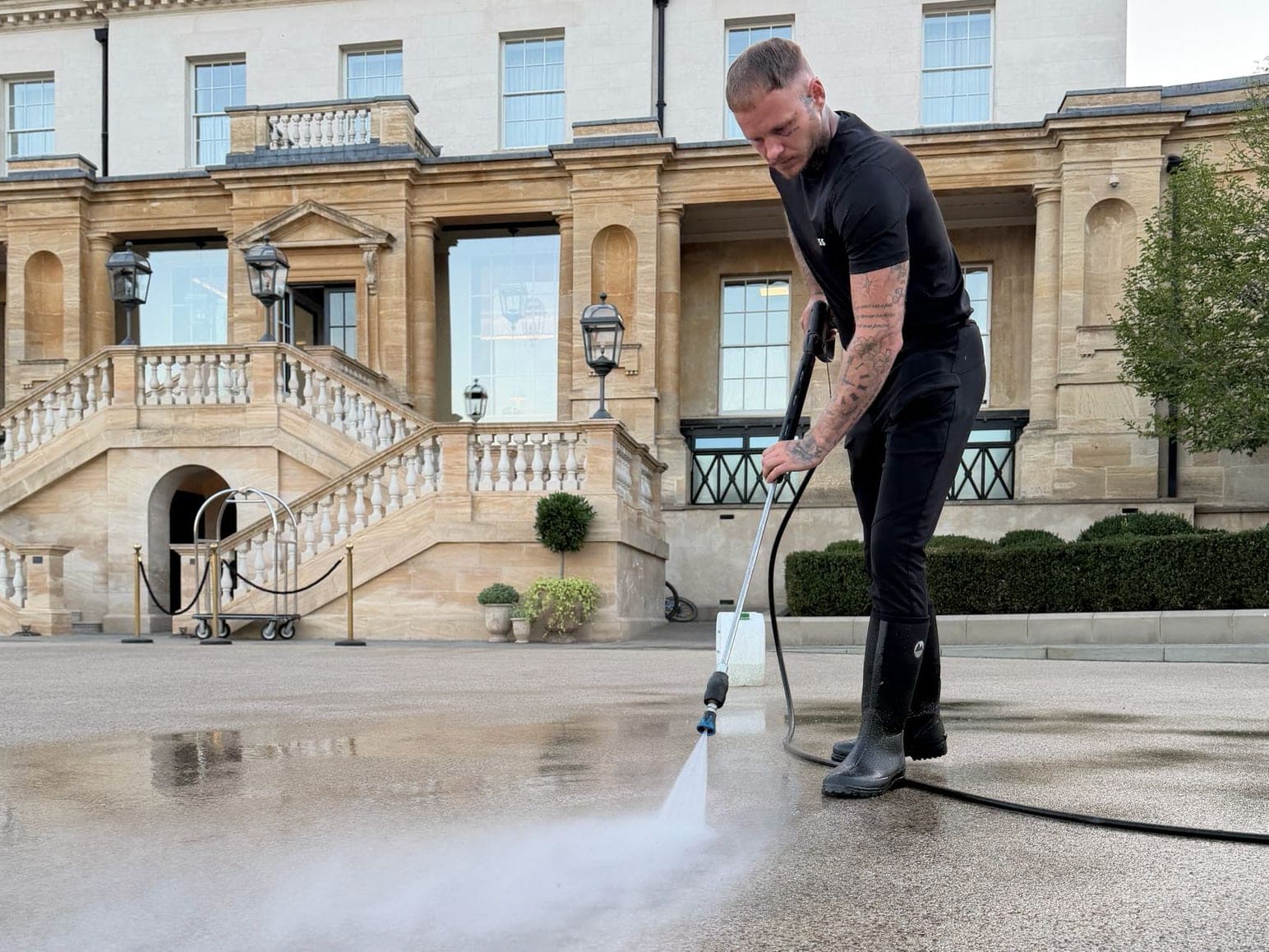 Chiltern Surface Co operative cleaning the stone forecourt of a country house, half restored