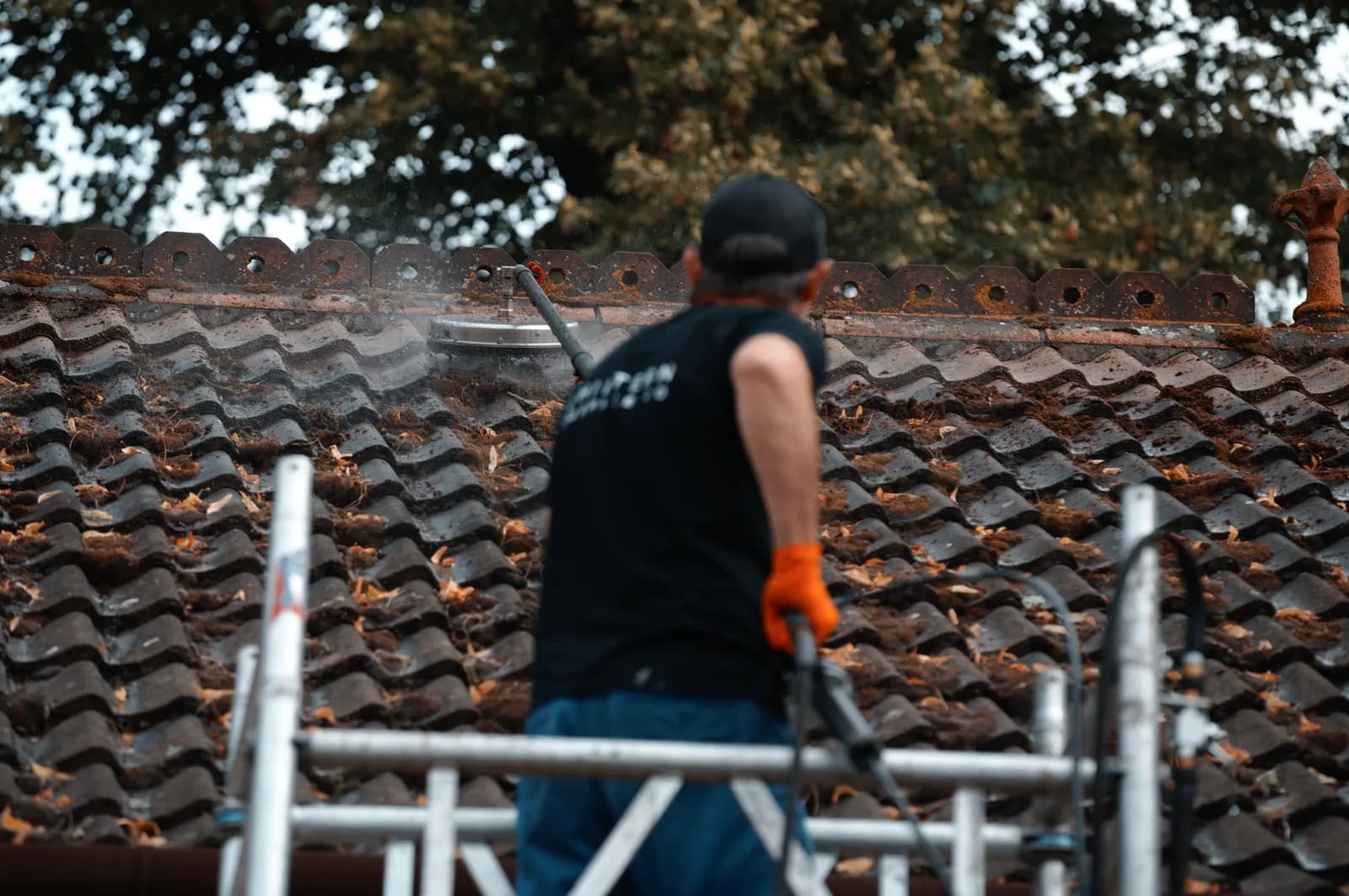 Chiltern Surface Co operative cleaning a tiled roof from a scaffold tower