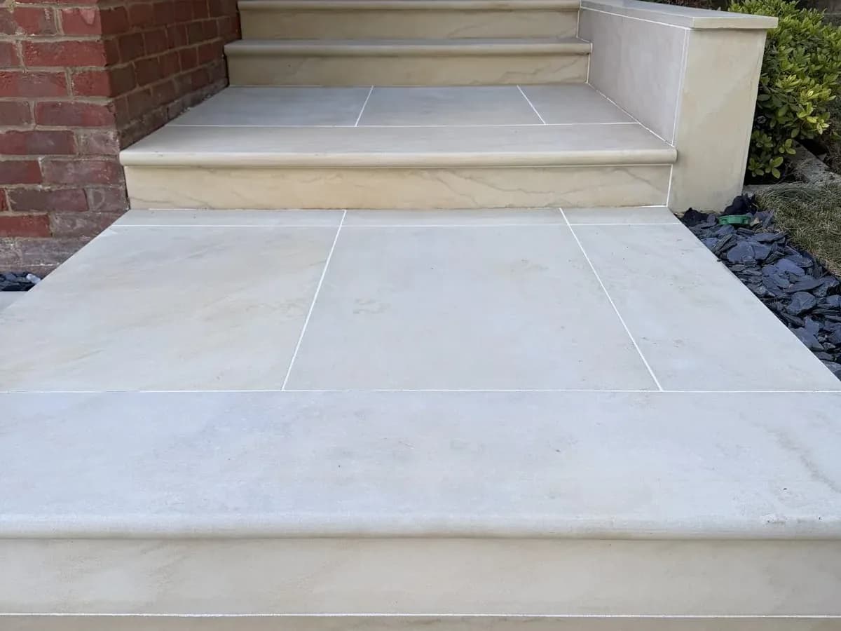 Sandstone entrance steps after cleaning, the stone pale and even from the path to the door