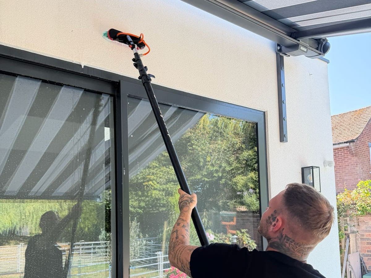 Chiltern Surface Co operative soft washing an exterior with a pole-fed brush at low pressure