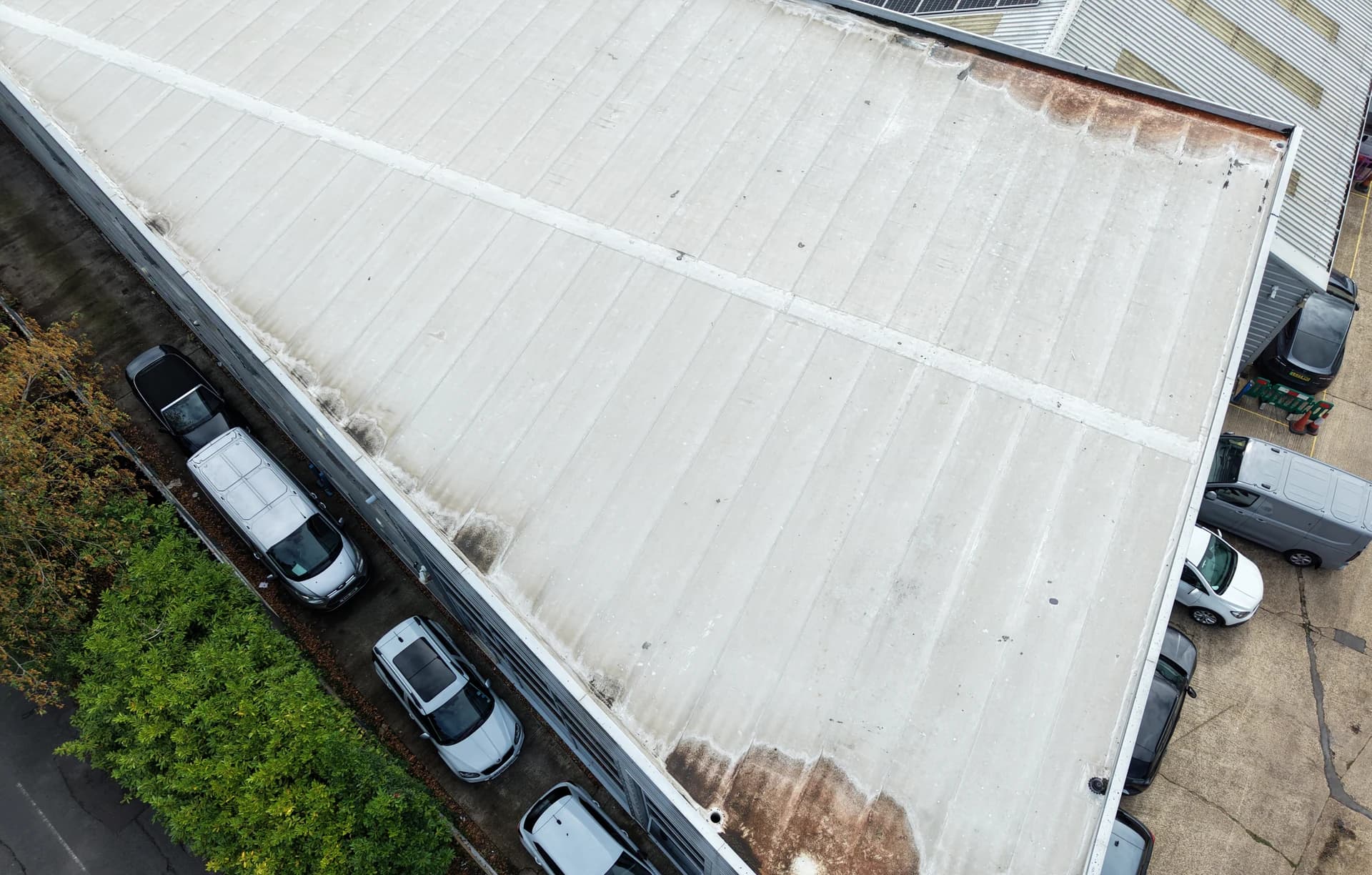 Aerial view of roof edges and cladding junctions with rust-brown run-off staining
