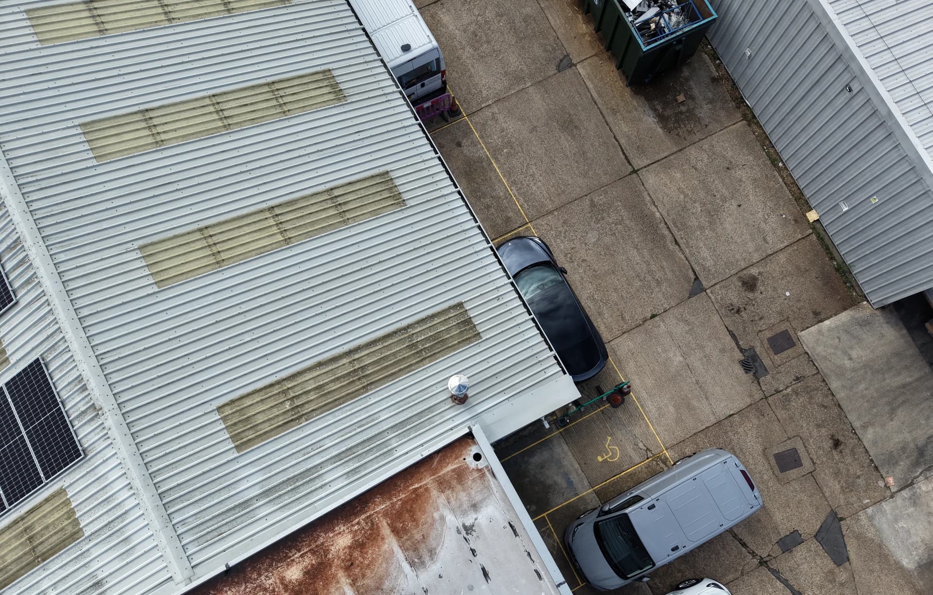 Aerial view of roof edges and cladding junctions with rust-brown run-off staining