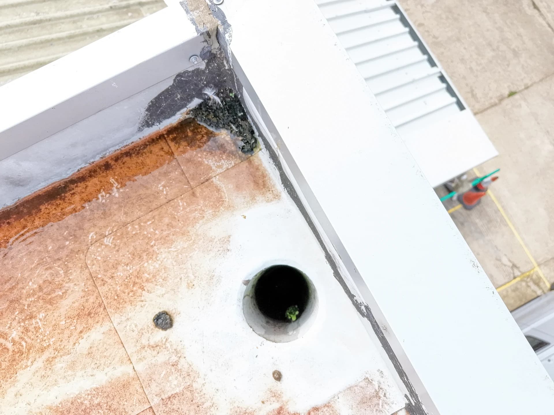Overexposed aerial view of a roof corner with an outlet and a rust stain