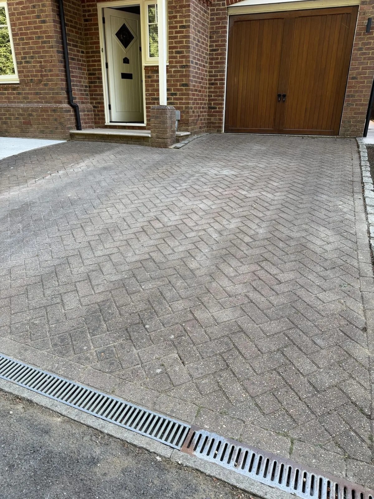 Block paved driveway in Hazlemere before cleaning: weathered, soiled herringbone paving in front of the house and garage