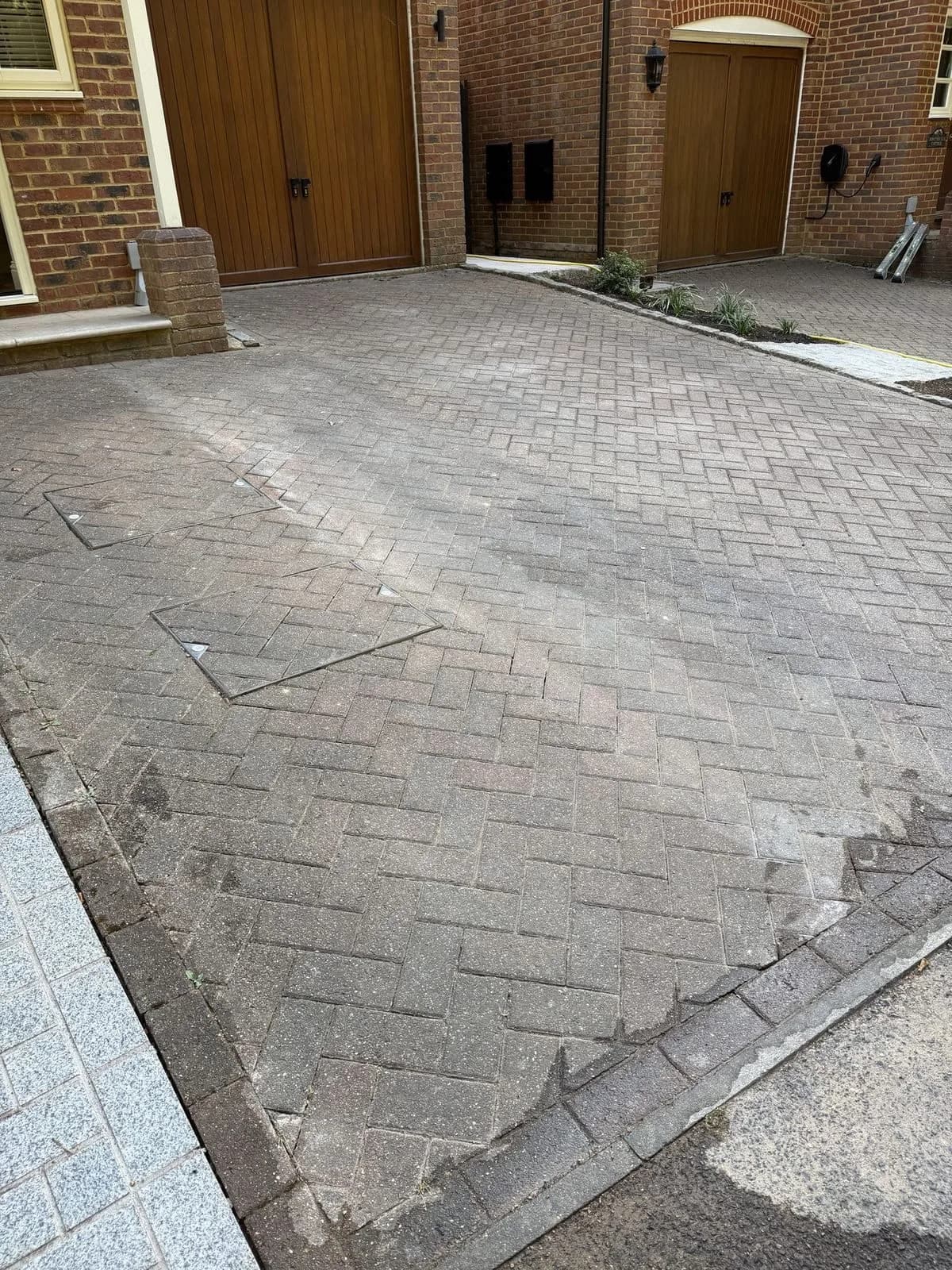 The block paved driveway before cleaning, photographed from the garage end towards the front door