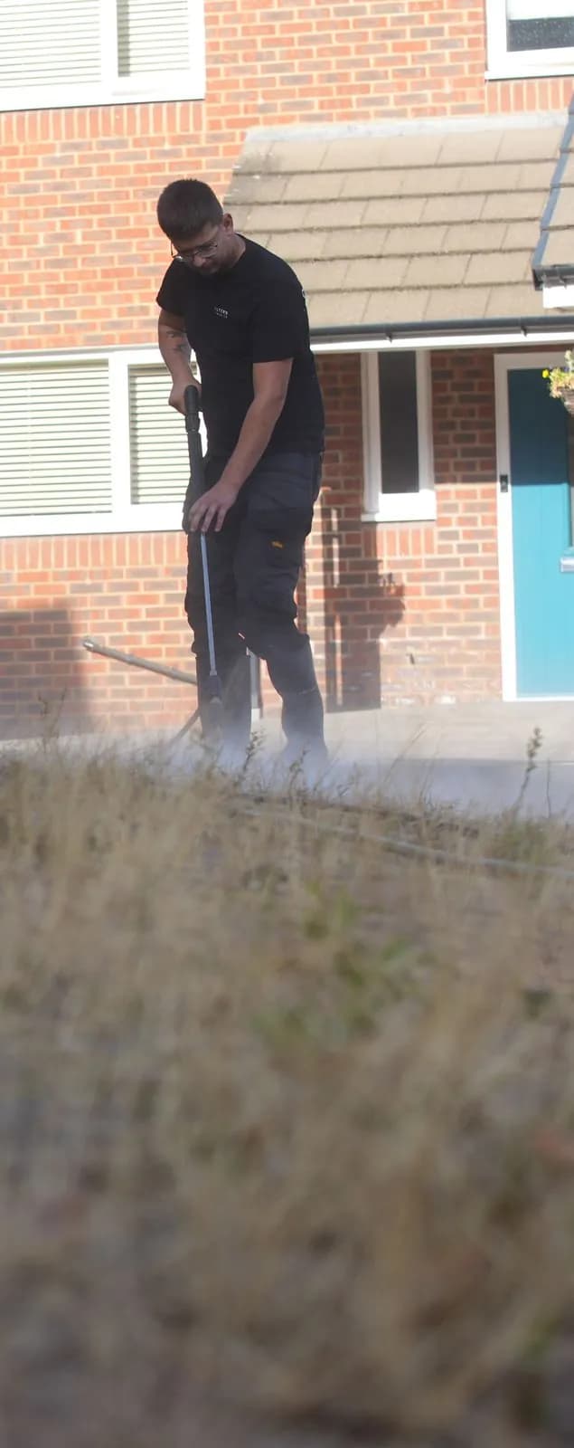 Chiltern Surface Co technician clearing the block paving joints with a lance