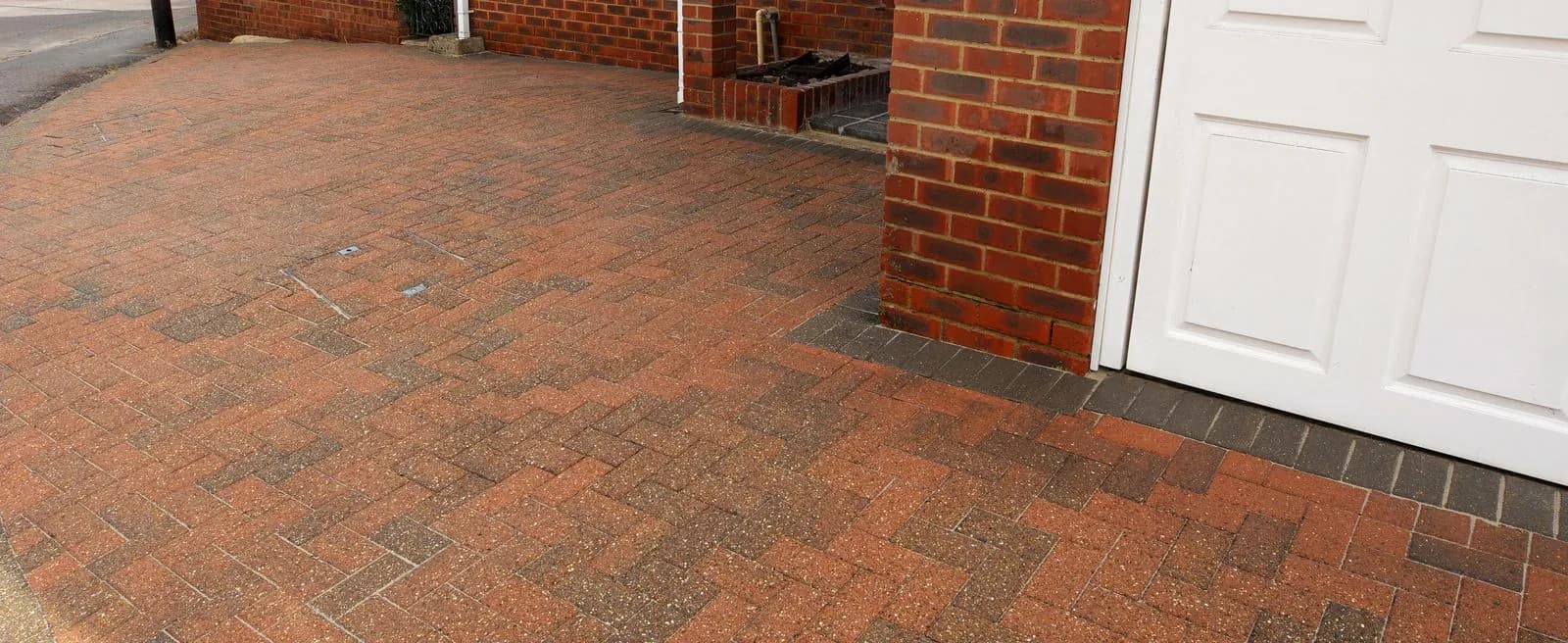 The same block paved driveway beside the garage after cleaning and re-sanding