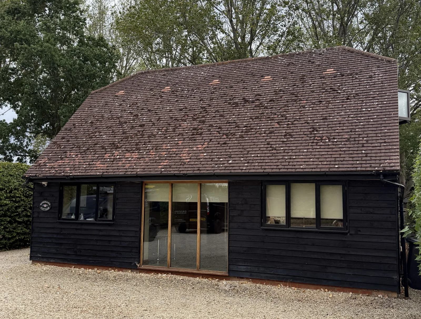 The annex in Aylesbury before cleaning, the clay tile roof dark with moss and organic contamination