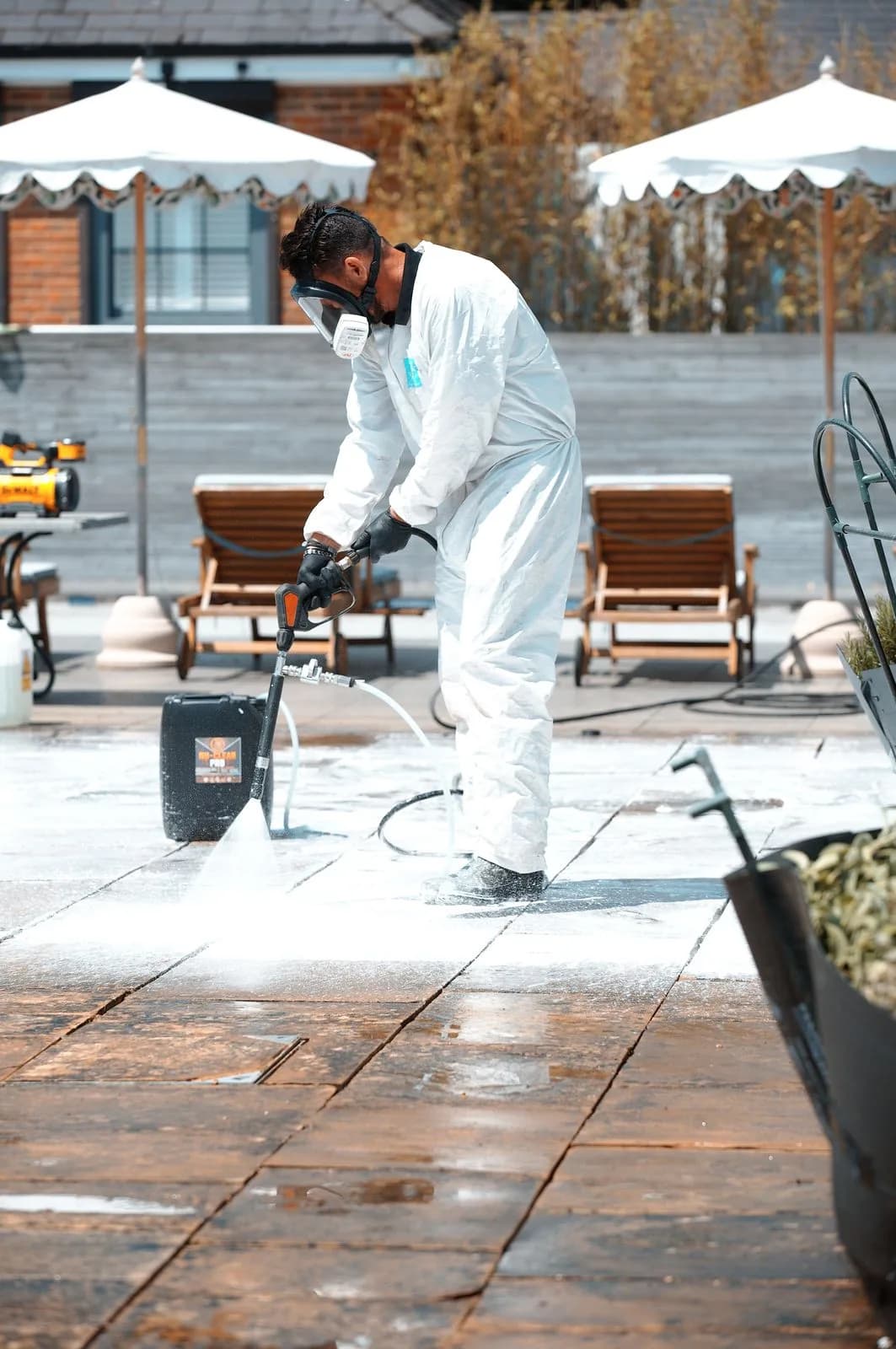 A Chiltern Surface Co technician applying chemical surface treatment to the Indian sandstone patio