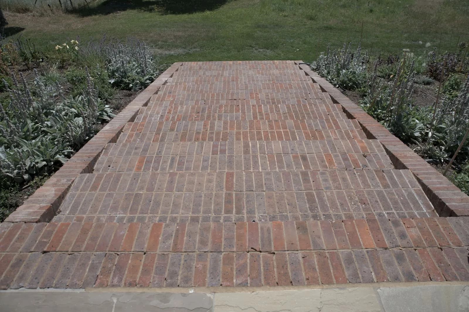 The brick pathway after cleaning, with the red brick colour recovered
