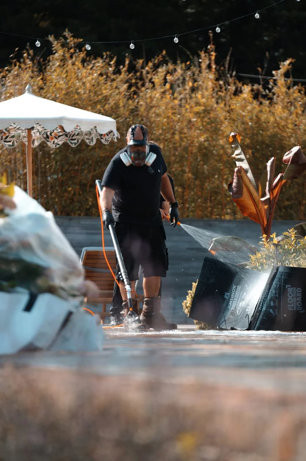 A Chiltern Surface Co technician spraying Chiltern EverGuard™ biocide treatment across the cleaned sandstone patio