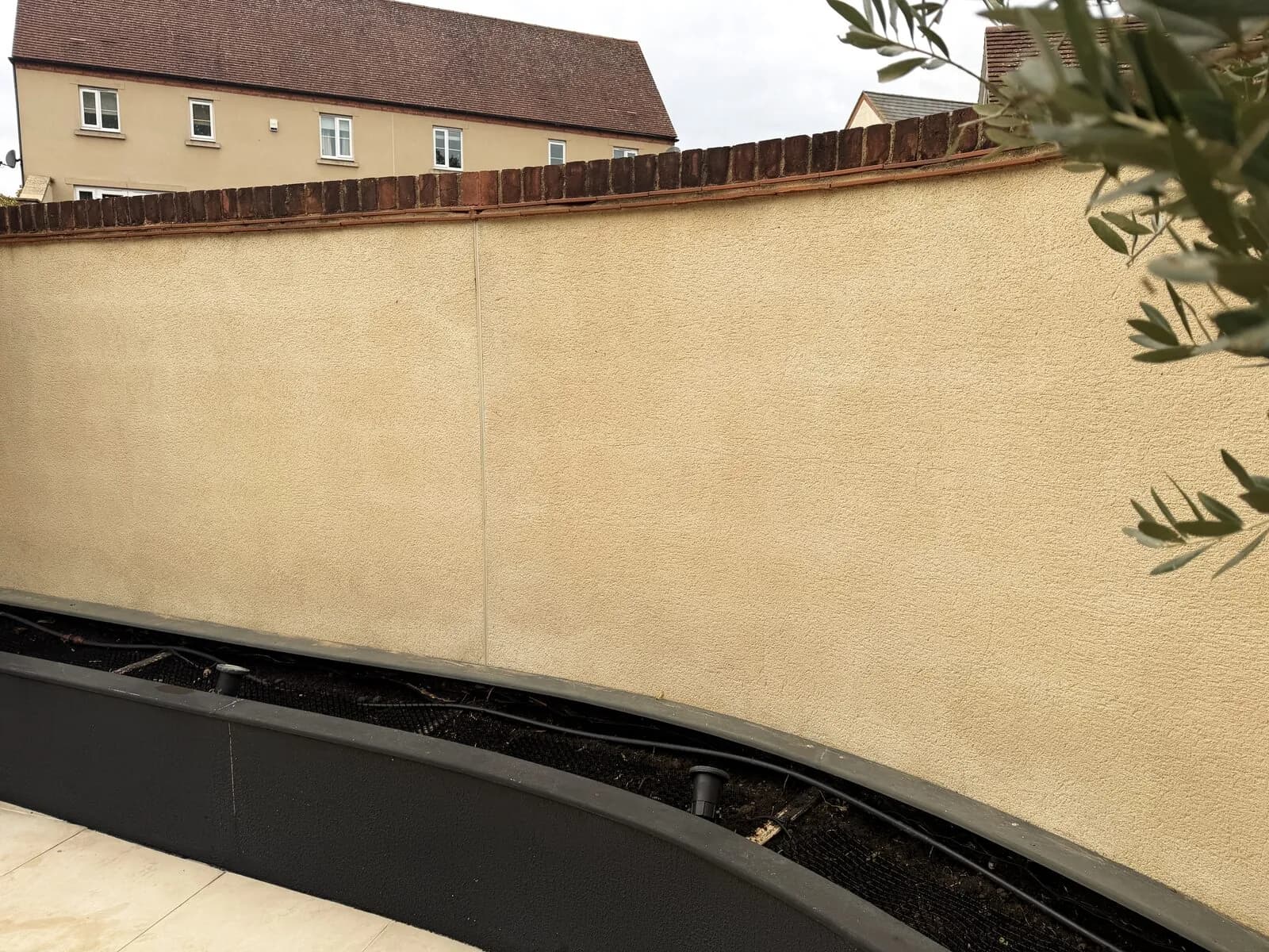 The same rendered garden wall after soft washing