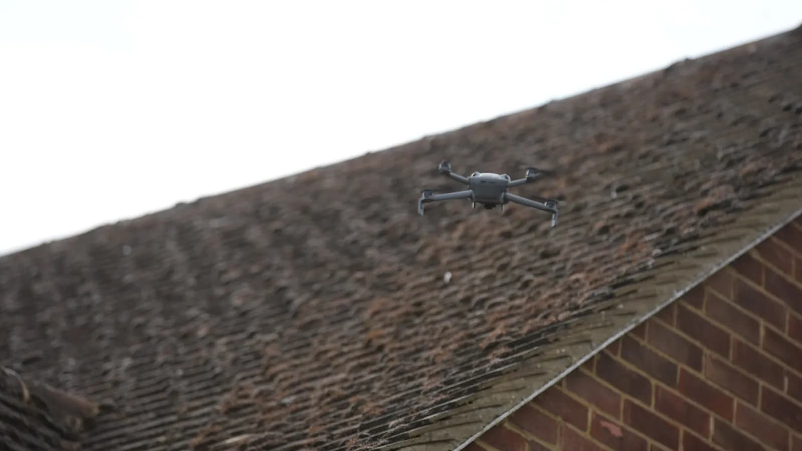 Chiltern Surface Co survey drone flying low over the moss-covered concrete tile roof in Great Missenden