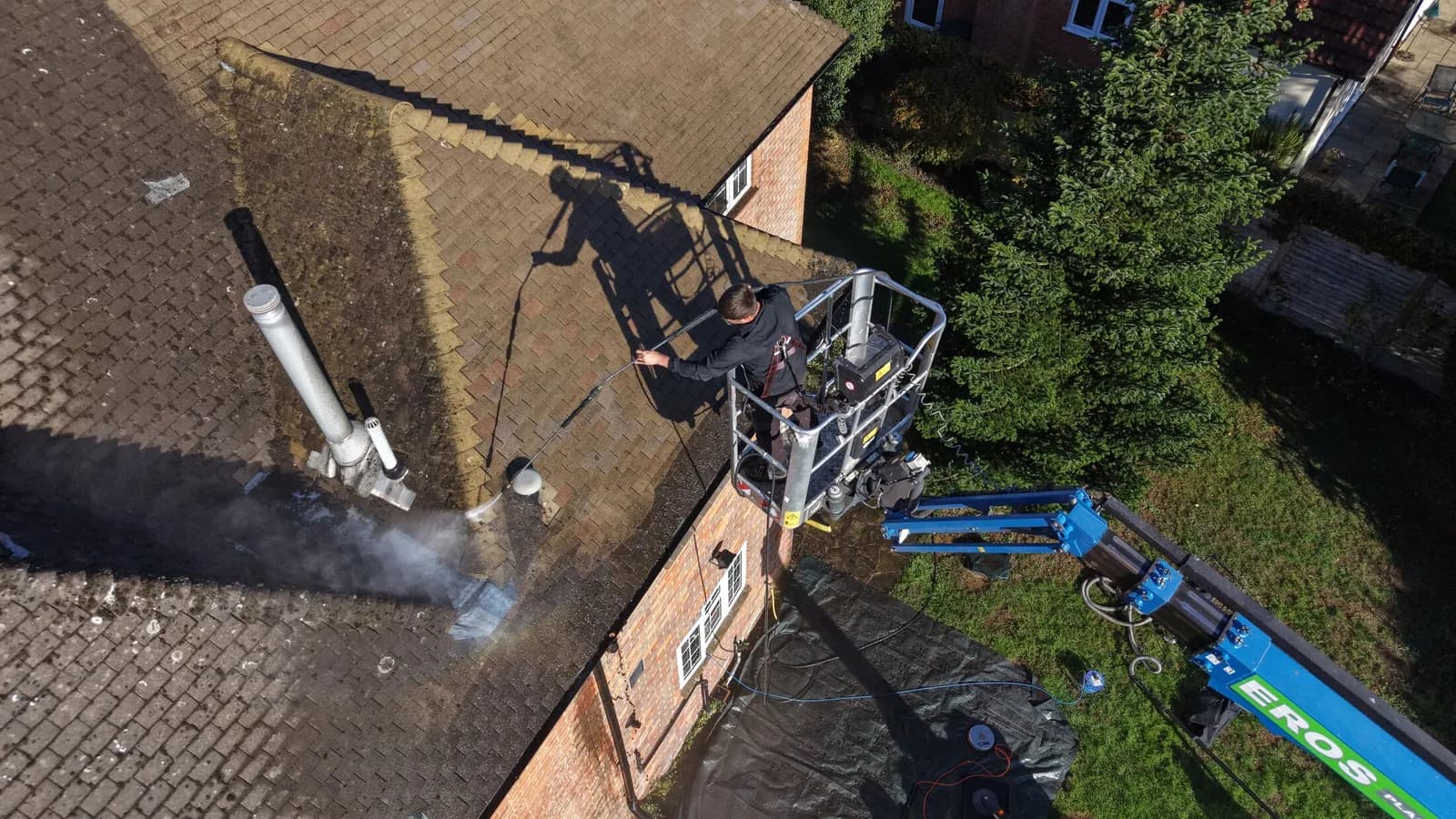 The powered access lift and a Chiltern Surface Co technician working the roof slope at low pressure in Great Missenden