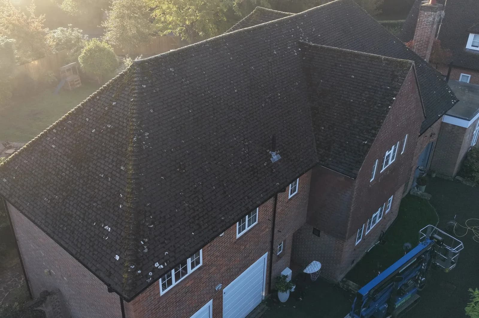 The roof at first light before cleaning — dark with moss and lichen