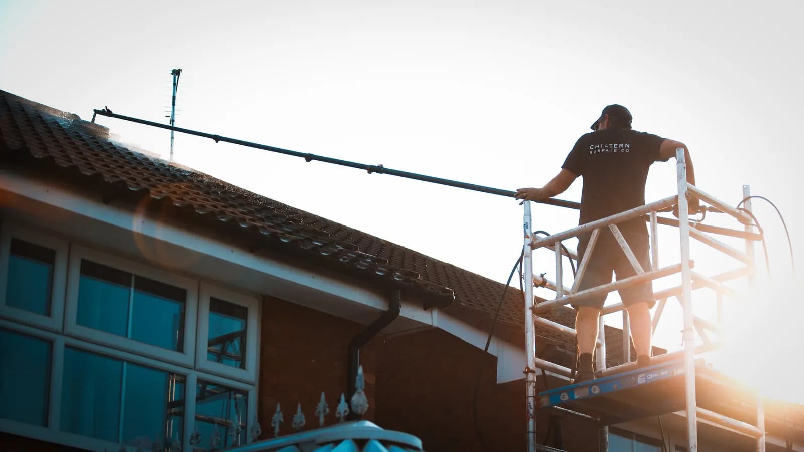 Chiltern Surface Co technician on the scaffold tower applying Chiltern EverGuard™ to the cleaned roof with a long lance