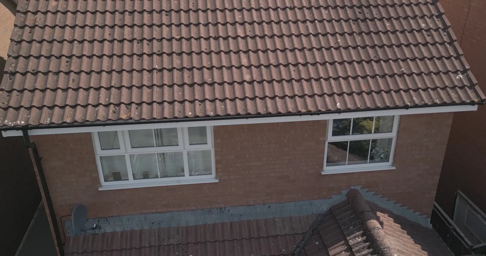 The same front roof before cleaning, dark with moss and algae, seen from the drone on the first morning