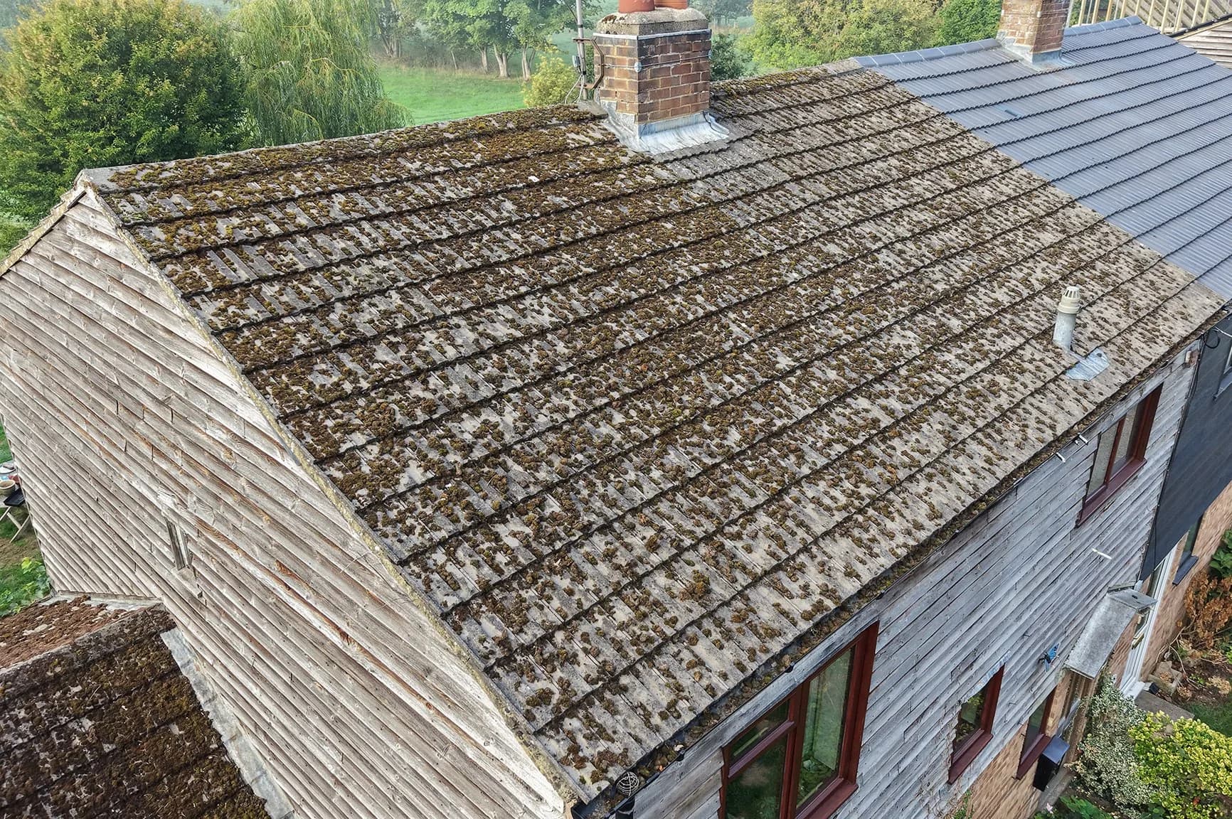 Concrete tile roof in Henley-on-Thames covered in moss before cleaning, seen from above