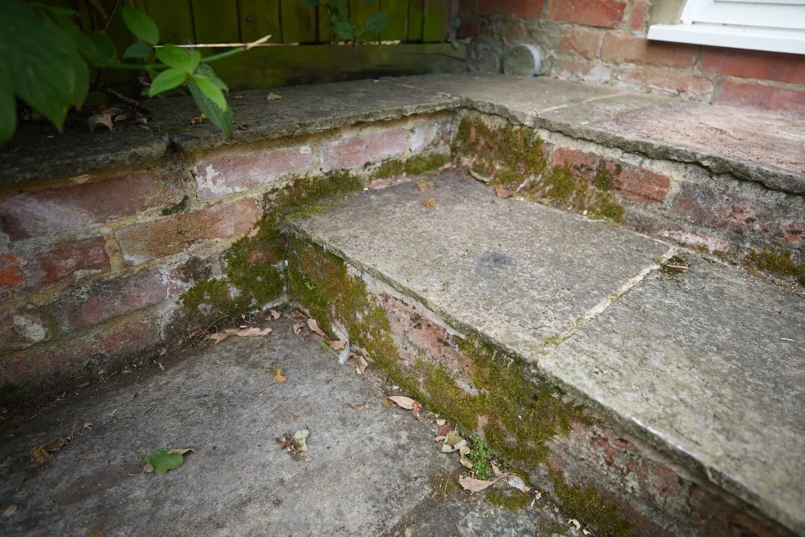 Moss-covered brick steps and sandstone before cleaning in Oxford