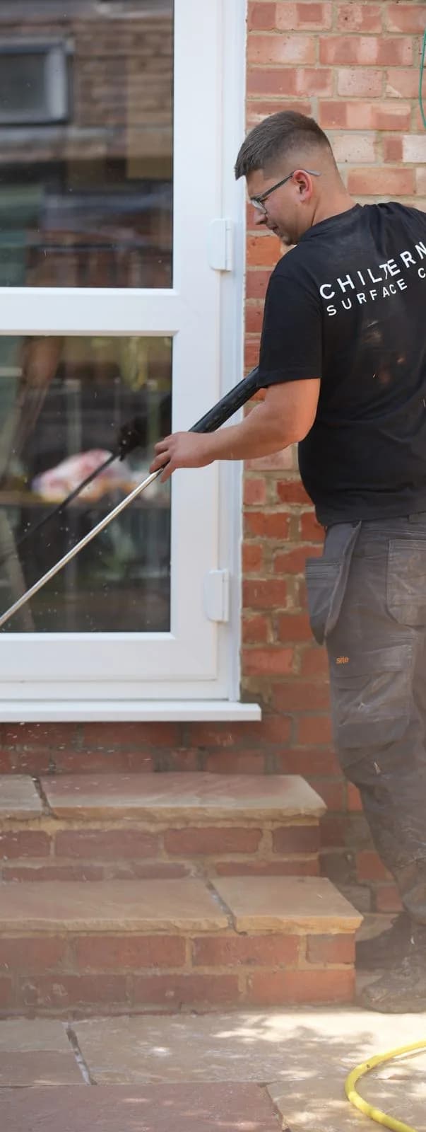Chiltern Surface Co technician cleaning the brick steps with a lance