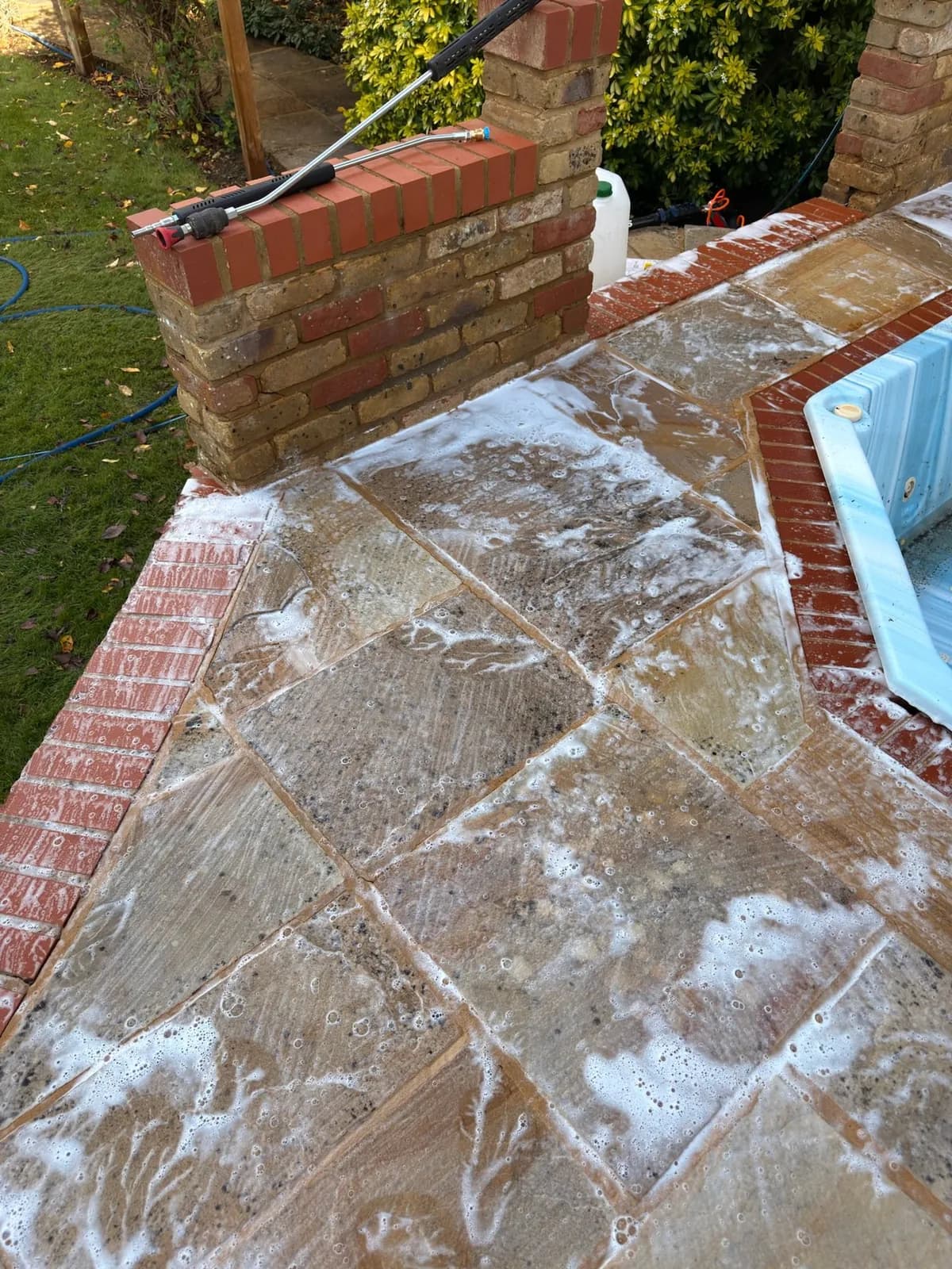 A brick pier and coping beside the hot tub during the works, the sandstone around it being cleaned and treated