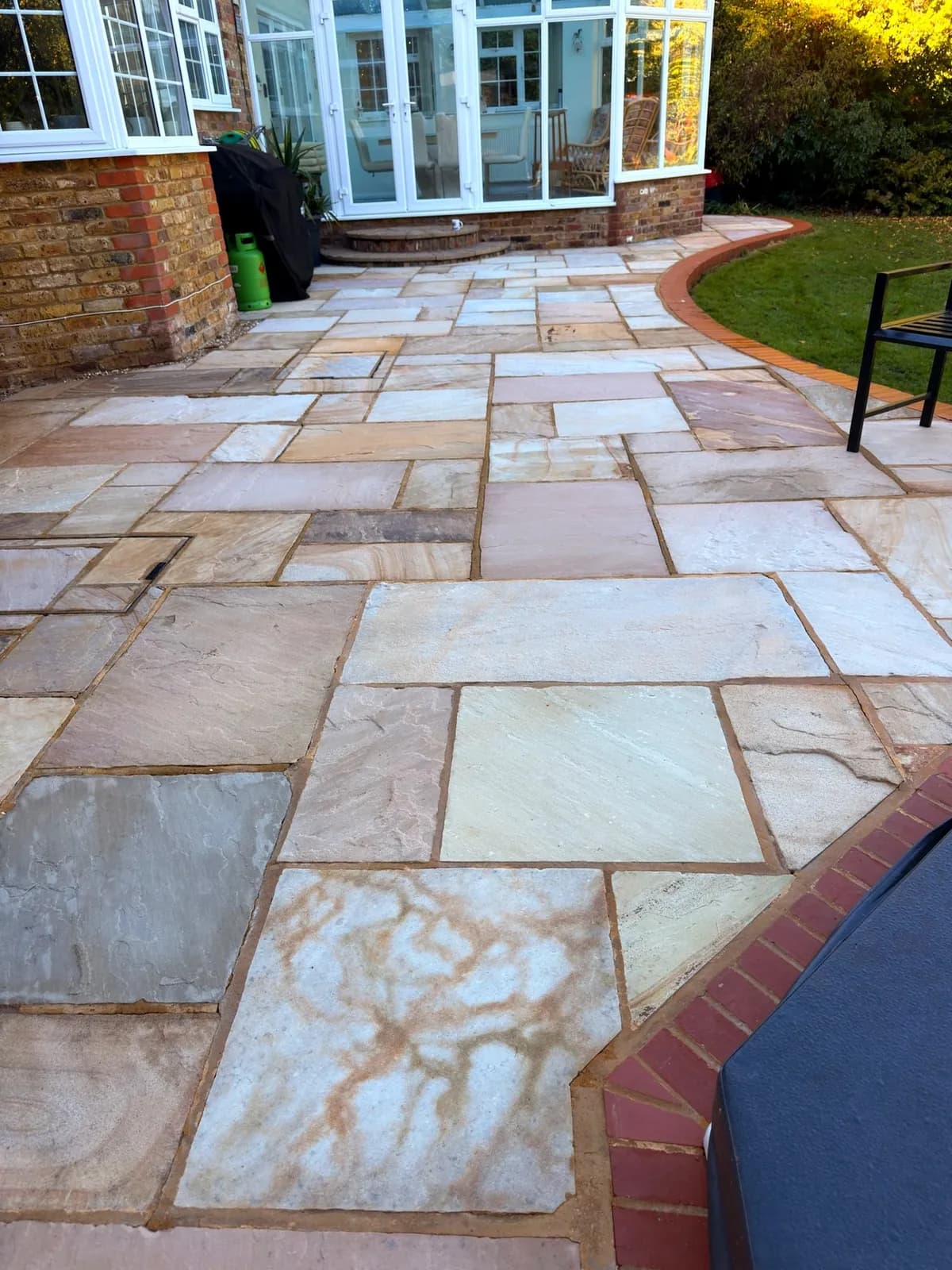 The finished Indian sandstone path leading to the conservatory, warm colour variation in every slab