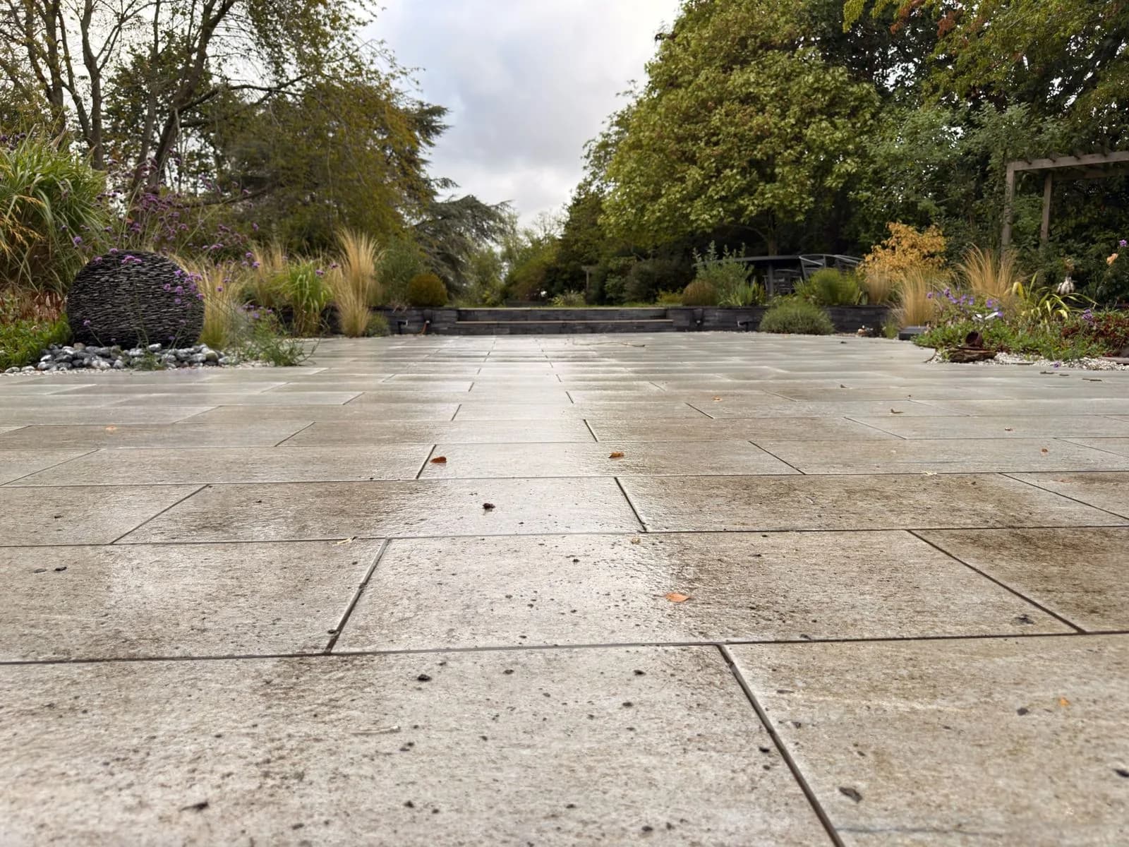 Porcelain patio in Stratford-upon-Avon before cleaning, dulled by algae and organic growth, looking towards the garden