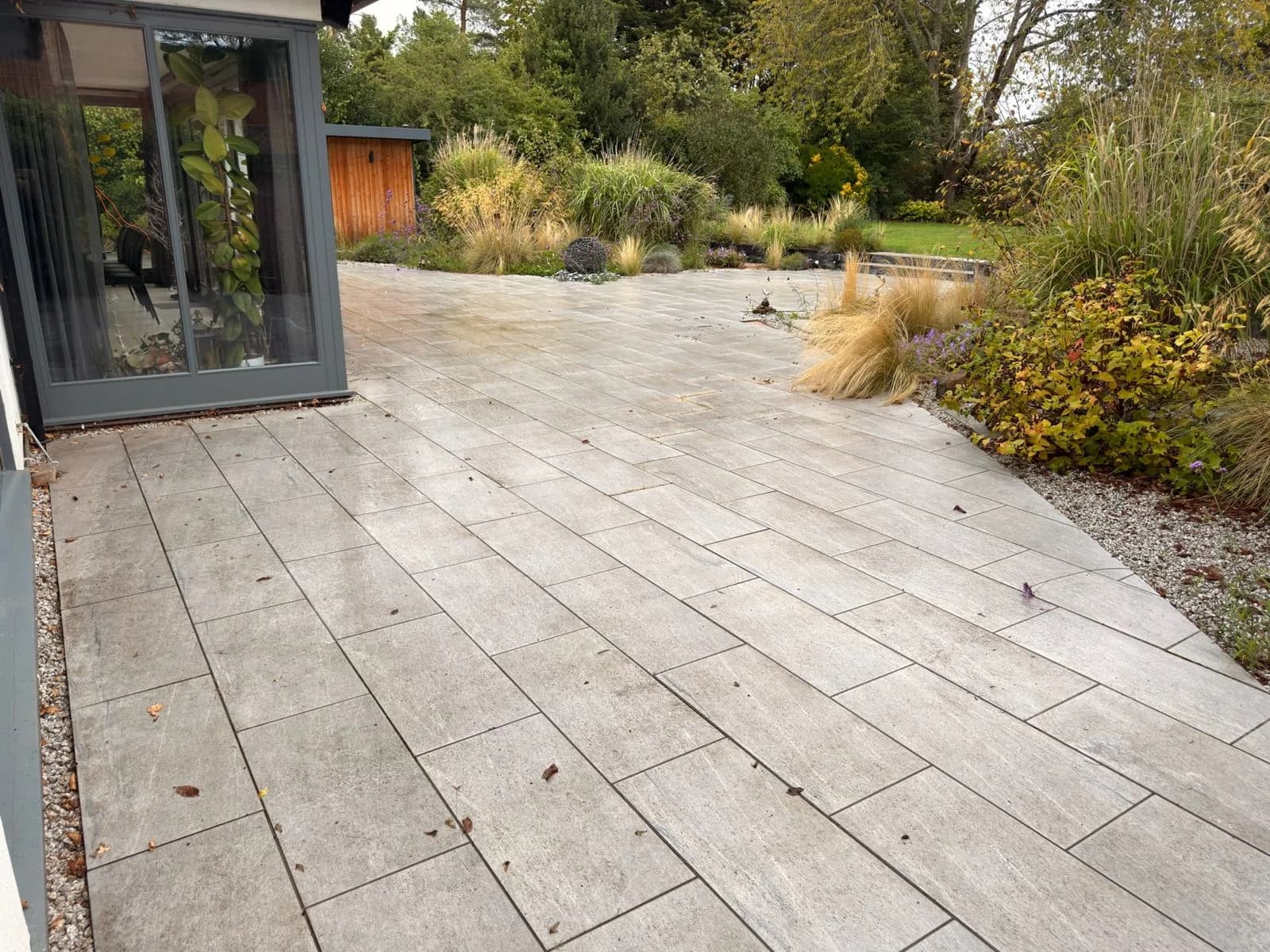 The porcelain patio beside the garden room before restoration, dirty and discoloured by algae