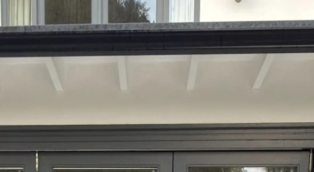 The same soffit and rafters after soft washing, clean white above the rear doors
