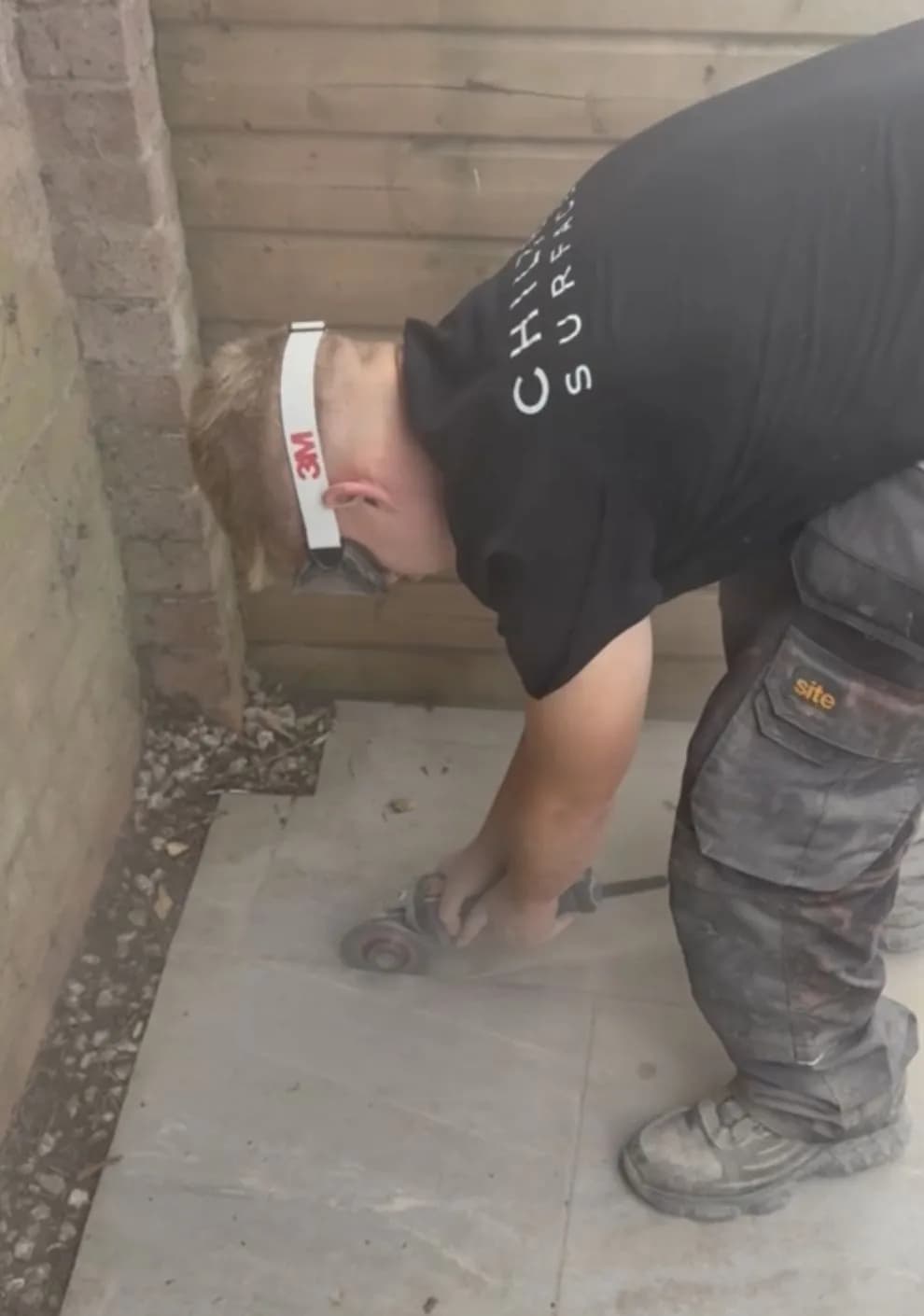 Chiltern Surface Co technician grinding out the old jointing between the porcelain tiles with an angle grinder